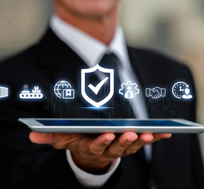 Businessman presenting digital supply chain and cybersecurity icons above a tablet